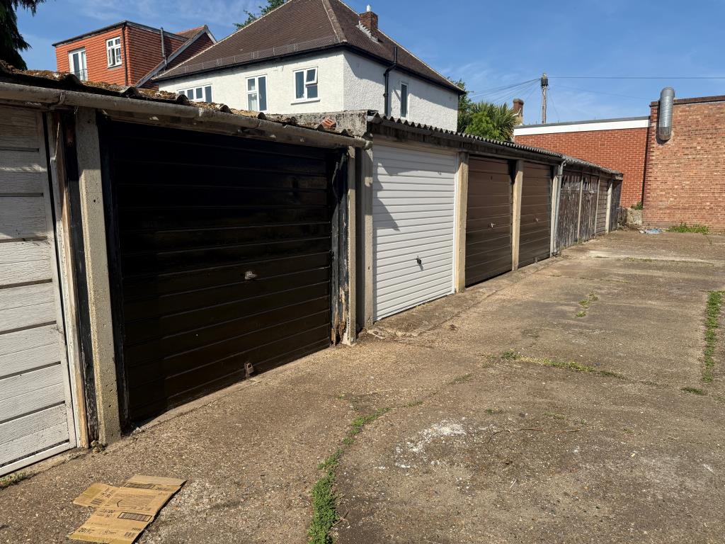 Lot: 17 - FOUR FREEHOLD GARAGES IN A COMPOUND - View of garages and forecourt